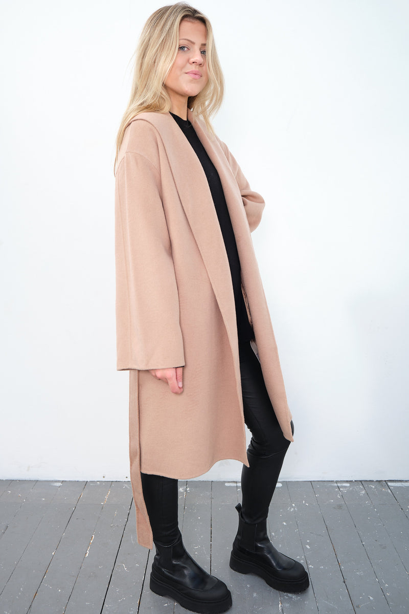 By Malene Birger Trullas kåpe i brun, med en sjal-lignende krage og en rett passform, laget av 100% ull.