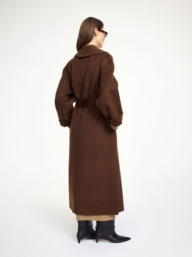 By Malene Birger Trullem kåpe i mørkebrun, med rett passform, laget av 100% ull, og sjal-lignende krage.