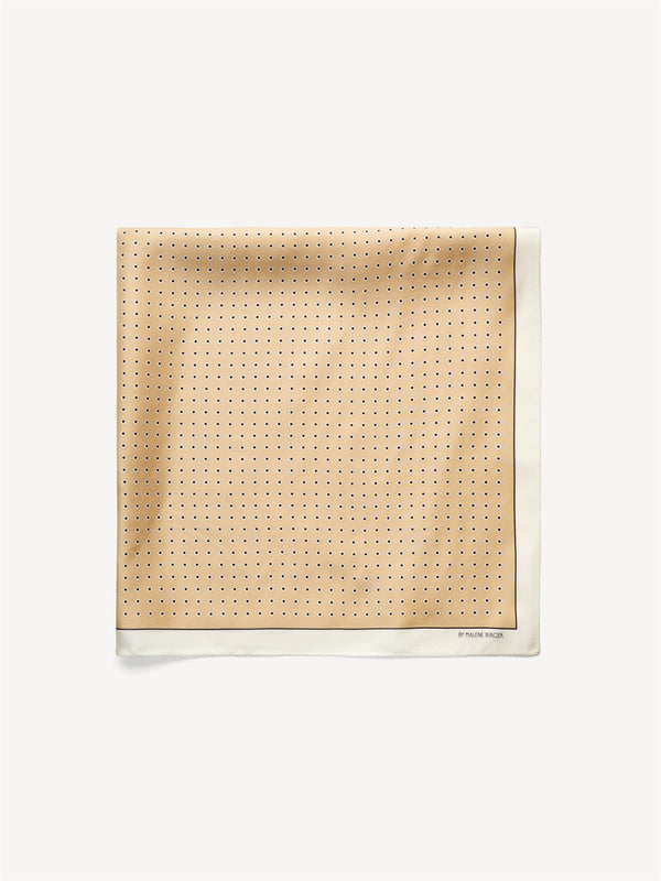 By Malene Birger Velia silkeskjerf i sand, laget av 100% silke med et elegant mønster og et lite logo i hjørnet.