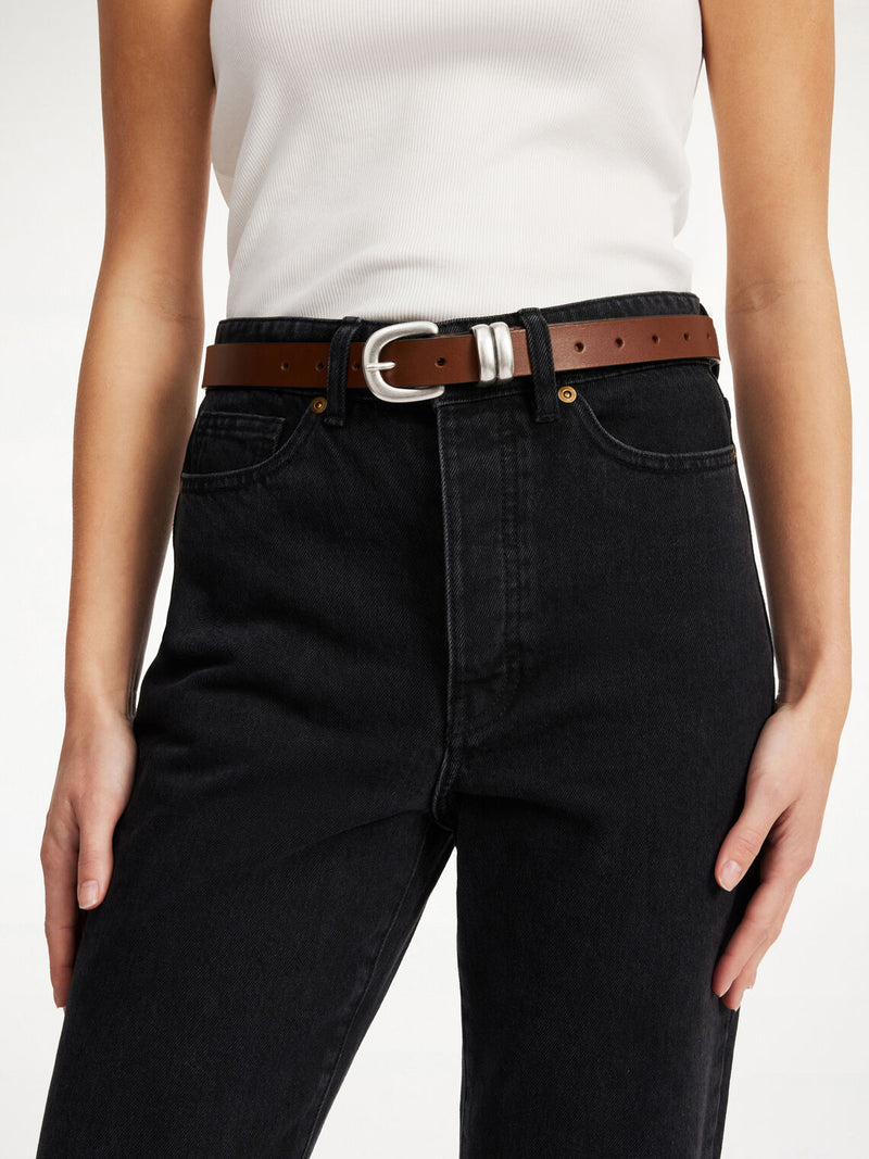 By Malene Birger Zoilo belte i brunt, laget av 100% kuskinn, med en sølvfarget spenne for et røffere uttrykk.