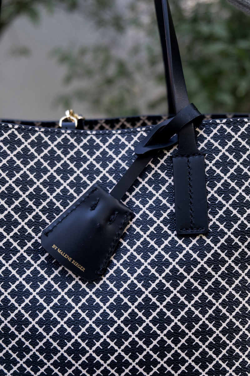 By Malene Birger Abi Tote veske i sort, med et nytt mikro-print Signature Flower-trykk, laget av polyvinylklorid med skinndetaljer.