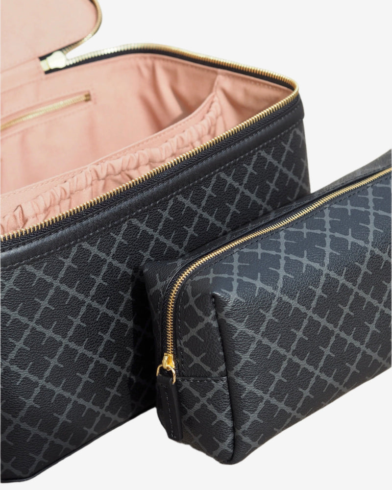 By Malene Birger Bae Beauty Box toalettmappe i mørkegrå, laget av polyvinylklorid med Signature Flower-print, med flere rom og en ekstra sminkepung.